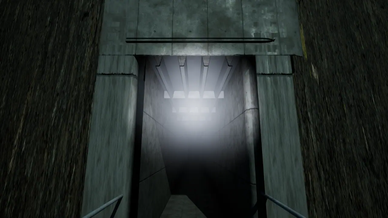 A concrete tunnel mouth lit from within, a metal handrail descending into it.